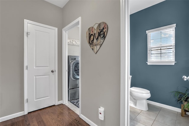 bathroom featuring washer / dryer, baseboards, toilet, and wood finished floors