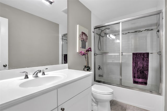 bathroom with enclosed tub / shower combo, vanity, toilet, and tile patterned floors