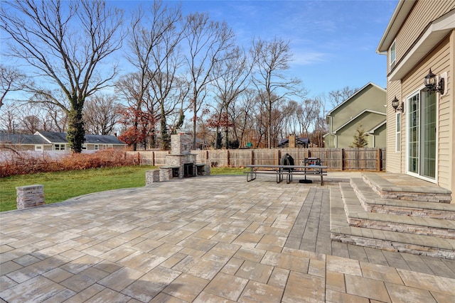 view of patio / terrace with an outdoor fireplace and fence private yard