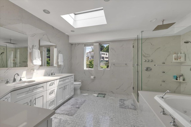 full bath with toilet, a garden tub, a marble finish shower, and a sink