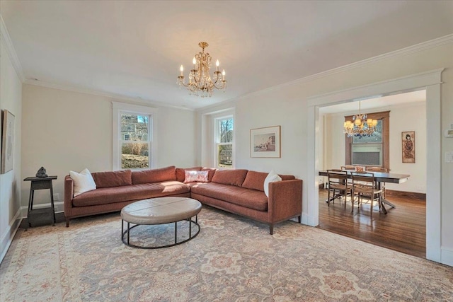 living area with baseboards, an inviting chandelier, wood finished floors, and ornamental molding