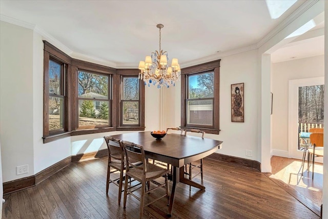 dining room with baseboards, a notable chandelier, dark wood-style floors, and crown molding