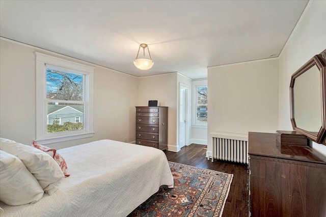 bedroom with dark wood finished floors, crown molding, radiator heating unit, and baseboards