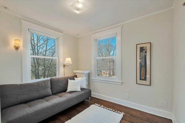 living area featuring crown molding, baseboards, and wood finished floors