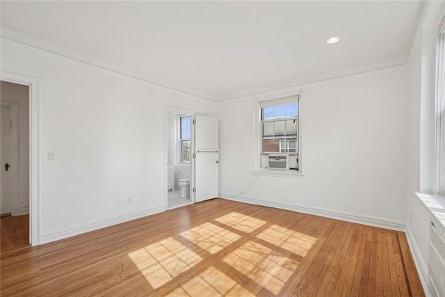 unfurnished room featuring cooling unit, crown molding, baseboards, and hardwood / wood-style flooring