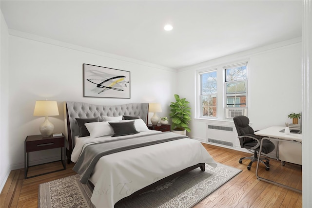 bedroom featuring baseboards, radiator, and hardwood / wood-style flooring