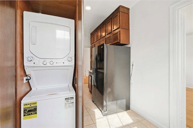 washroom featuring light tile patterned flooring and stacked washer and clothes dryer