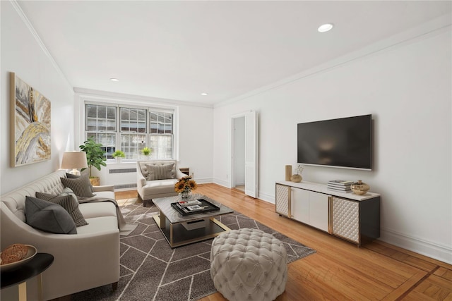 living room featuring baseboards, radiator heating unit, ornamental molding, and wood finished floors