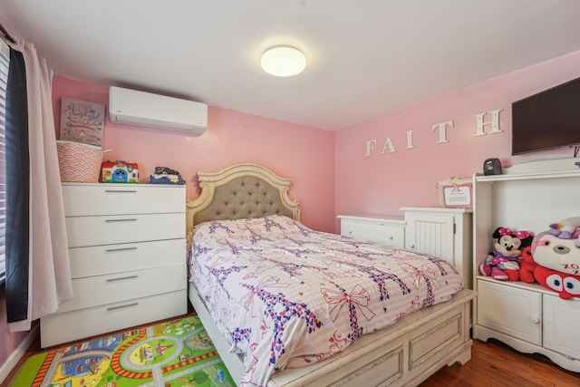 bedroom with a wall unit AC and wood finished floors