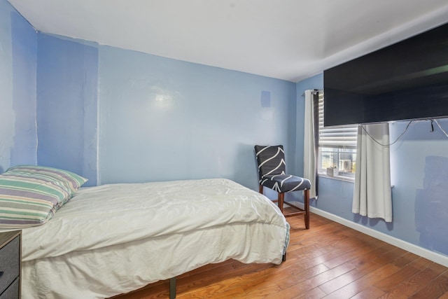 bedroom with hardwood / wood-style flooring and baseboards