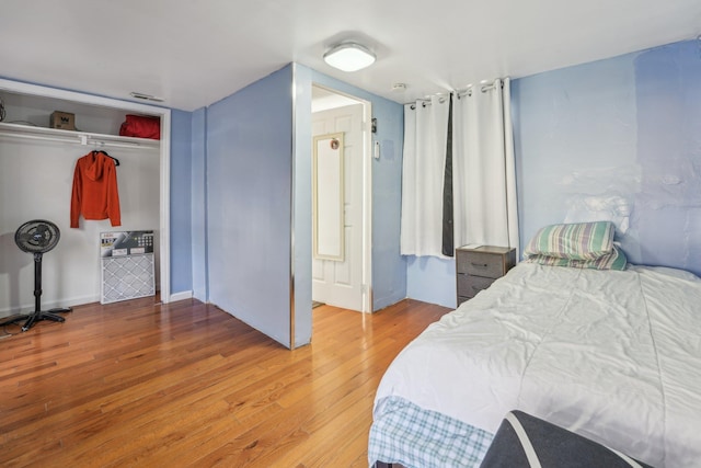 bedroom featuring light wood finished floors, a closet, and visible vents