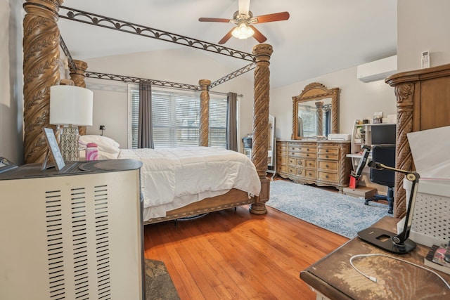 bedroom with a wall mounted air conditioner, vaulted ceiling, hardwood / wood-style floors, and ceiling fan