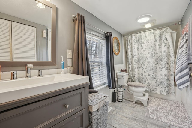 bathroom featuring vanity, toilet, and wood finished floors