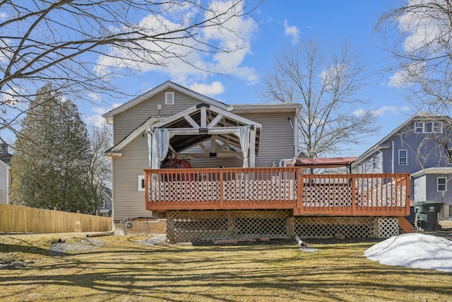 back of property with a yard, fence, and a wooden deck