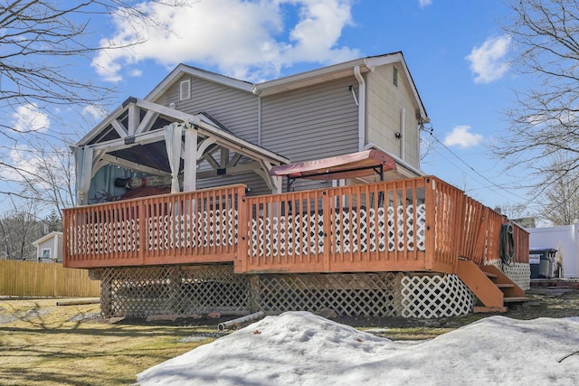 back of property featuring a wooden deck and fence