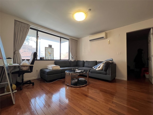 living area with an AC wall unit, wood finished floors, and baseboards