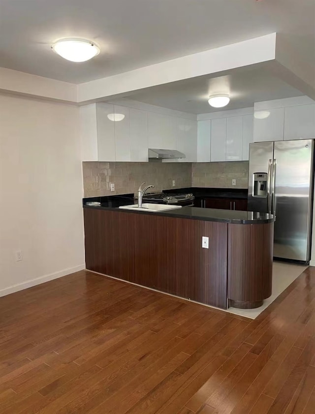 kitchen with stainless steel fridge, modern cabinets, and white cabinets