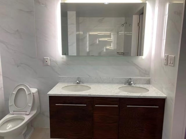 full bath featuring double vanity, toilet, a shower, and a sink