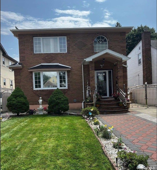 traditional-style house with brick siding, a front yard, and fence