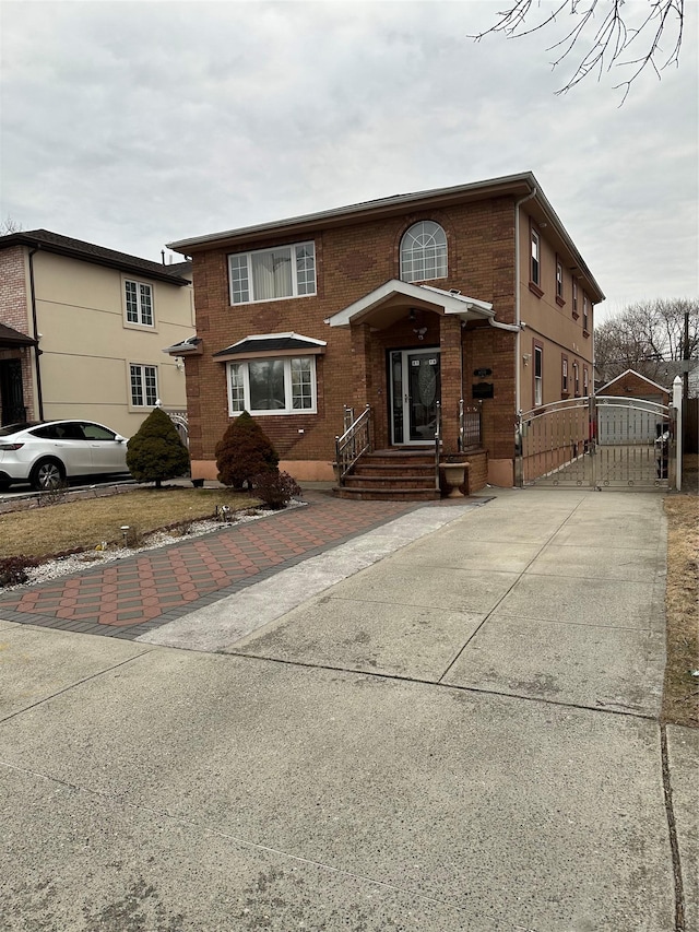 traditional-style home with a gate and brick siding