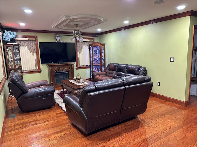 living room featuring recessed lighting, ornamental molding, a high end fireplace, wood finished floors, and baseboards