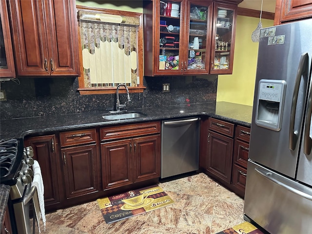 kitchen with stainless steel appliances, tasteful backsplash, a sink, and glass insert cabinets