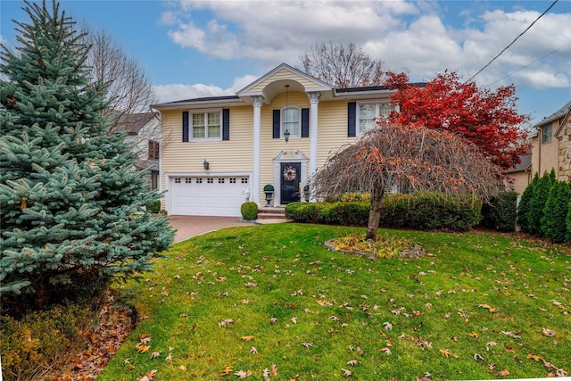 view of front of house with an attached garage, concrete driveway, and a front yard