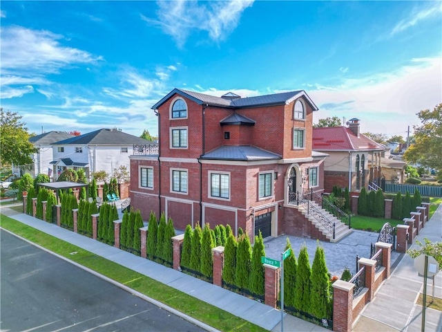 view of front facade featuring a garage, brick siding, fence, driveway, and a residential view