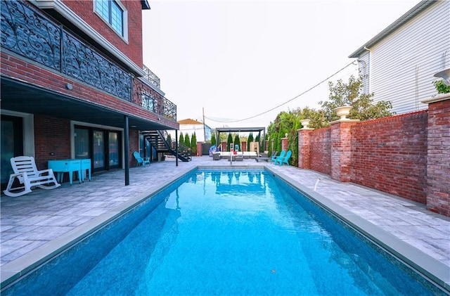 view of swimming pool with stairs, a patio, fence, and a fenced in pool