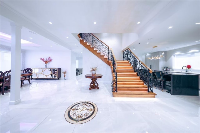 stairway with recessed lighting and ornate columns