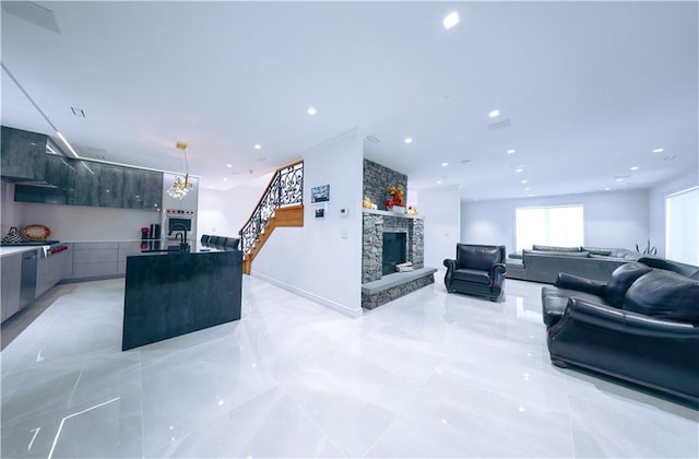 living room featuring recessed lighting, a stone fireplace, stairway, and baseboards