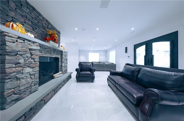 living room with recessed lighting, french doors, and a stone fireplace