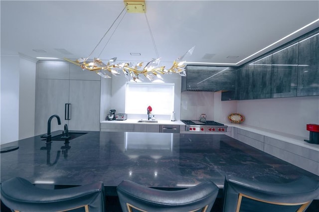 kitchen with stainless steel gas stovetop, a sink, modern cabinets, a kitchen breakfast bar, and extractor fan