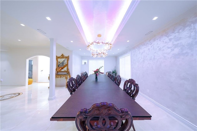 dining room featuring a tray ceiling, arched walkways, crown molding, recessed lighting, and baseboards