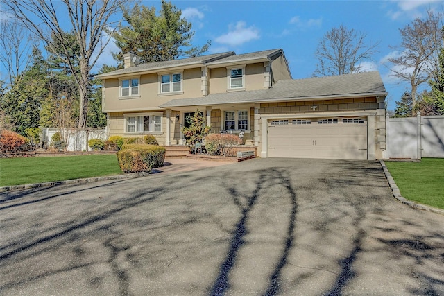 view of front facade featuring fence, a front yard, a chimney, driveway, and an attached garage