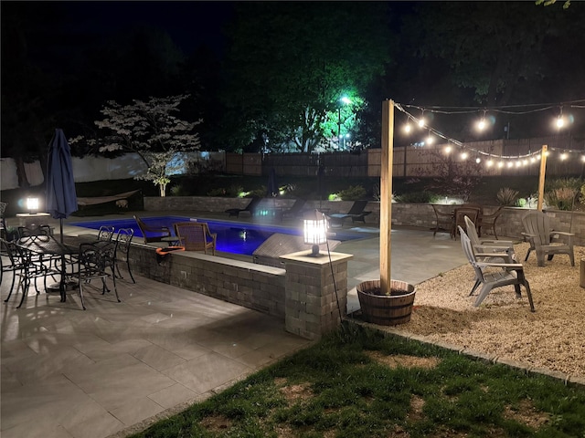 pool at twilight featuring a fenced backyard, a fenced in pool, and a patio area