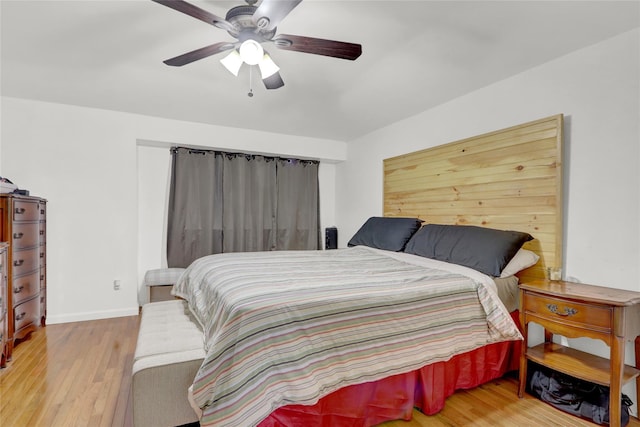 bedroom with wood finished floors, a ceiling fan, and baseboards