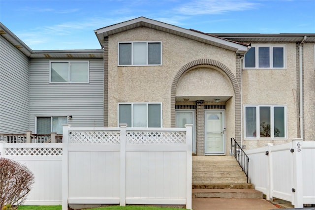 multi unit property with fence and stucco siding