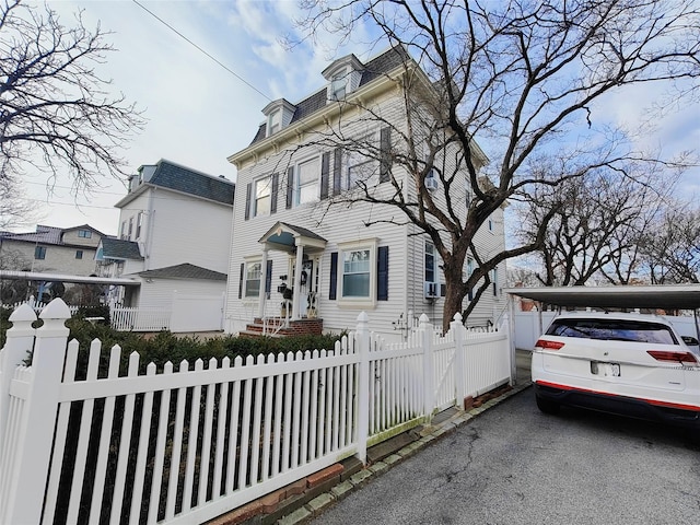 view of front of home with a fenced front yard and mansard roof