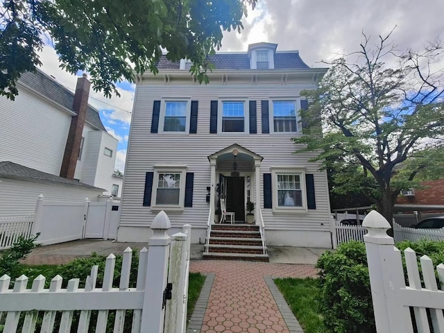 324 150th St, Whitestone, NY 11357 - second empire-style home with a fenced front yard, a gate, and mansard roof