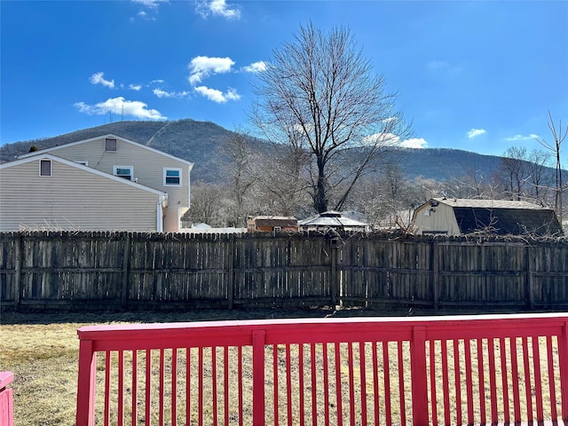 view of yard featuring fence and a mountain view