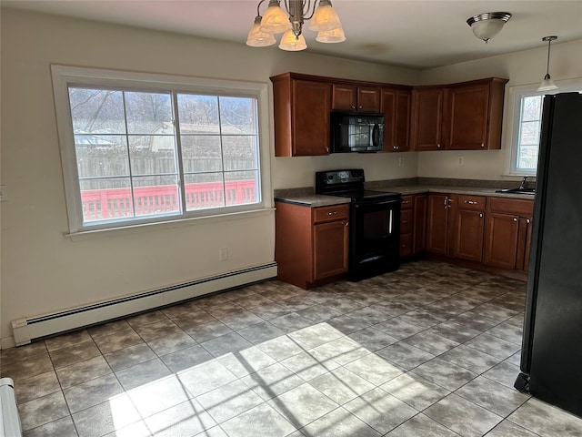 kitchen featuring a baseboard heating unit, a wealth of natural light, dark countertops, and black appliances