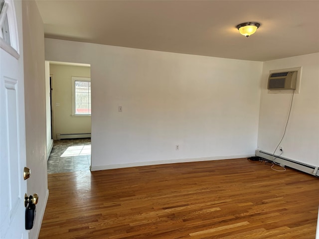 empty room with an AC wall unit, baseboards, baseboard heating, and wood finished floors