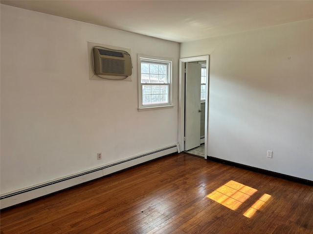 empty room featuring hardwood / wood-style floors, a baseboard radiator, baseboards, and an AC wall unit