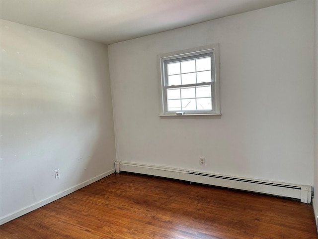 unfurnished room with baseboards, baseboard heating, and wood finished floors