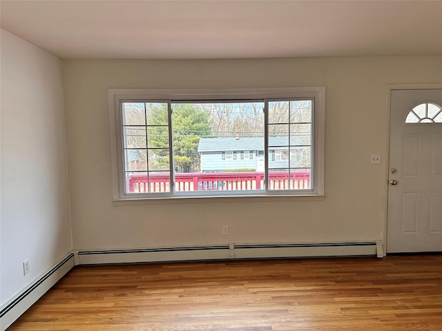 foyer entrance featuring a wealth of natural light, light wood-type flooring, and baseboard heating