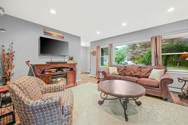 living room featuring a glass covered fireplace, wood finished floors, and recessed lighting