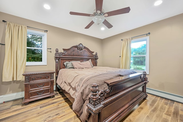 bedroom featuring a baseboard heating unit, recessed lighting, light wood finished floors, and a baseboard radiator