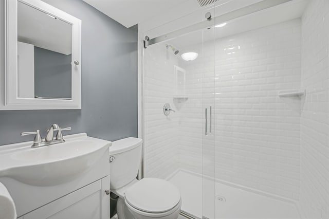 full bath featuring toilet, a shower stall, and vanity