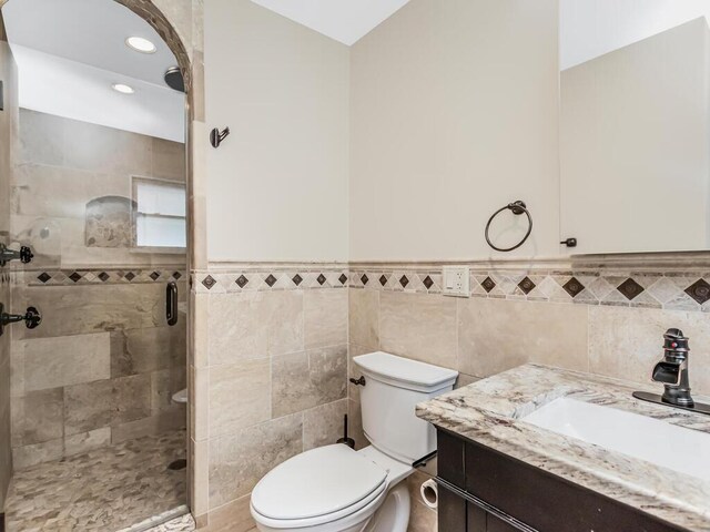 16 Joan Dr, Yonkers, NY 10704 - full bath with vanity, toilet, a shower stall, a wainscoted wall, and tile walls